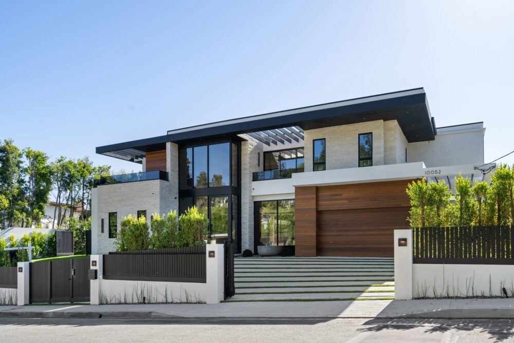 A modern two-story custom home featuring white siding, black window frames, and a clean contemporary architectural design.